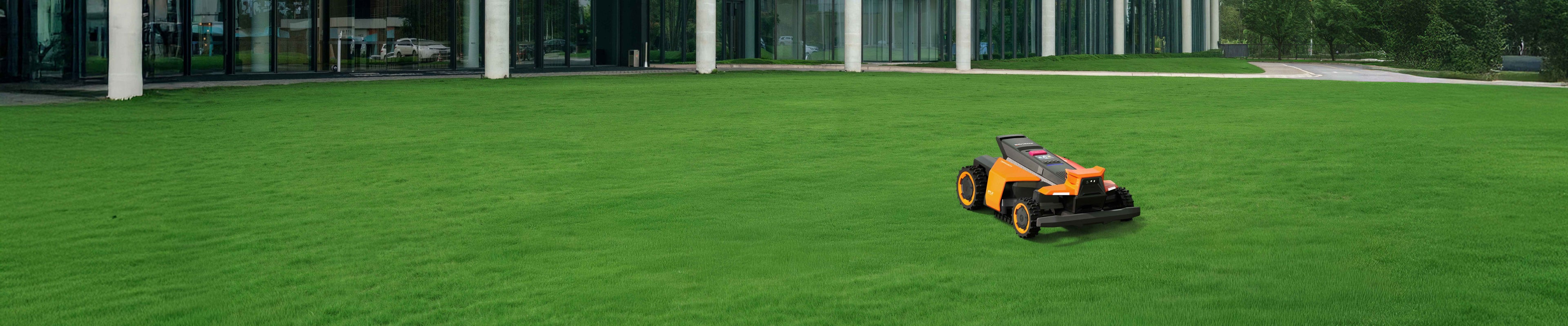 Navimow i110N robot lawn mower mows grass by glass building.