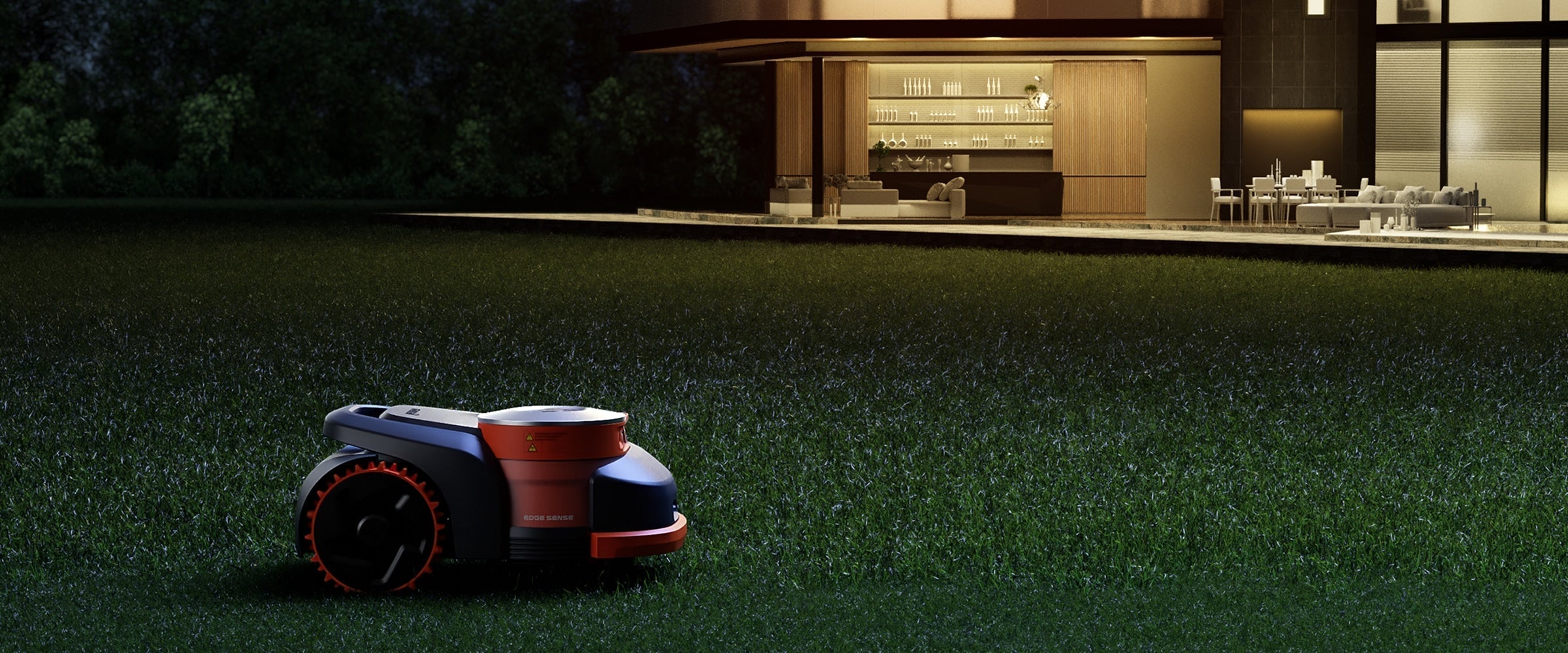 Segway Navimow H2 robot lawn mower at night on grass outside a warmly lit patio and bar area