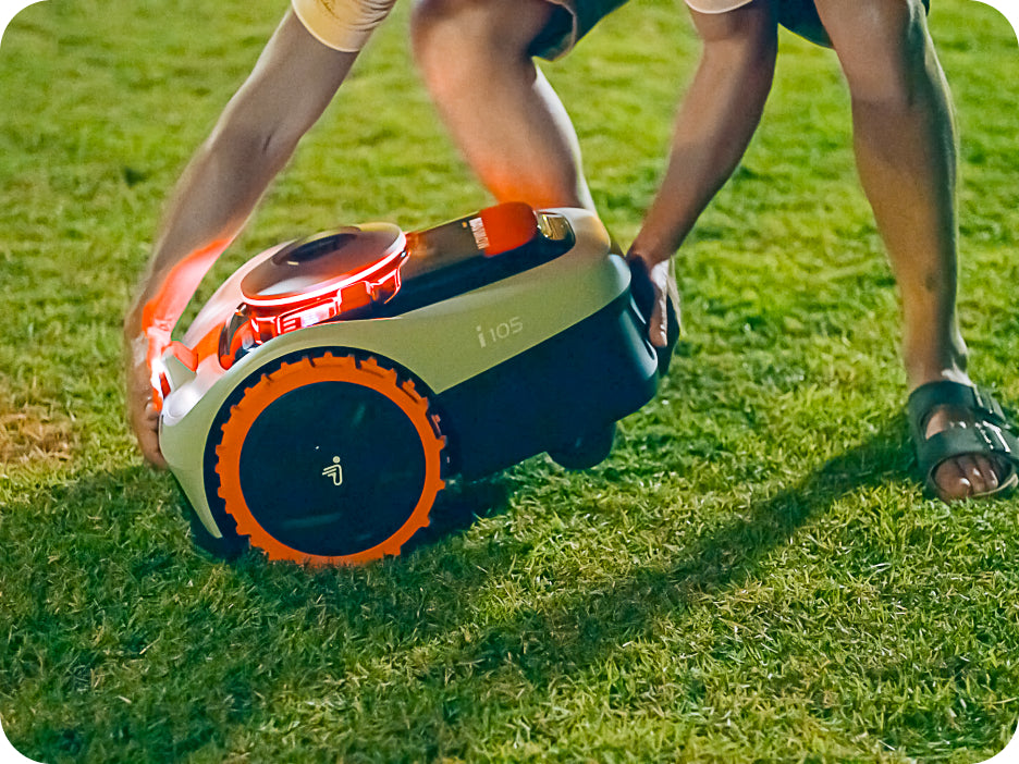 A person carries the Navimow i 105 robot lawn mower.