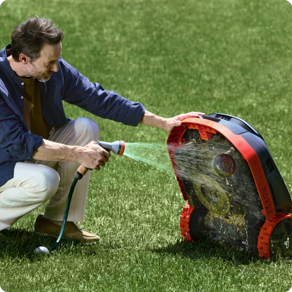 Navimow i Series robot lawn mower being sprayed with water.