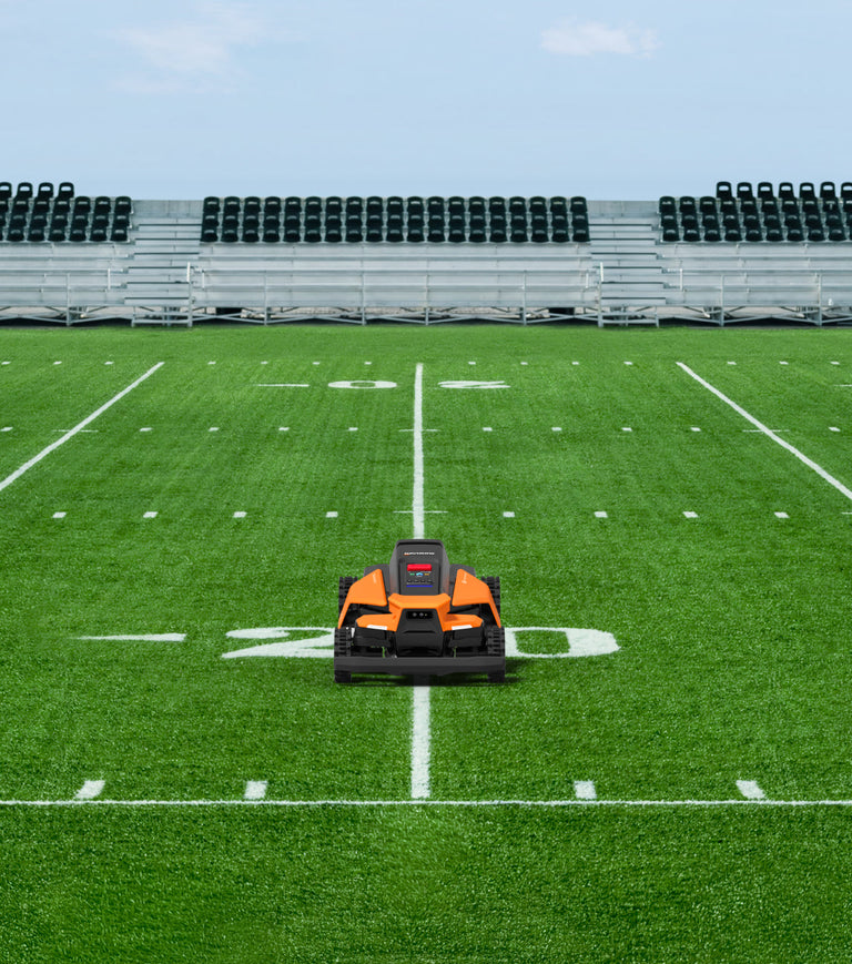 Navimow i110N robot lawn mower on a green football field.