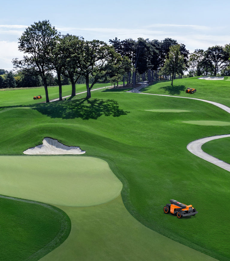 Navimow i110N robot lawn mower on a green golf course.