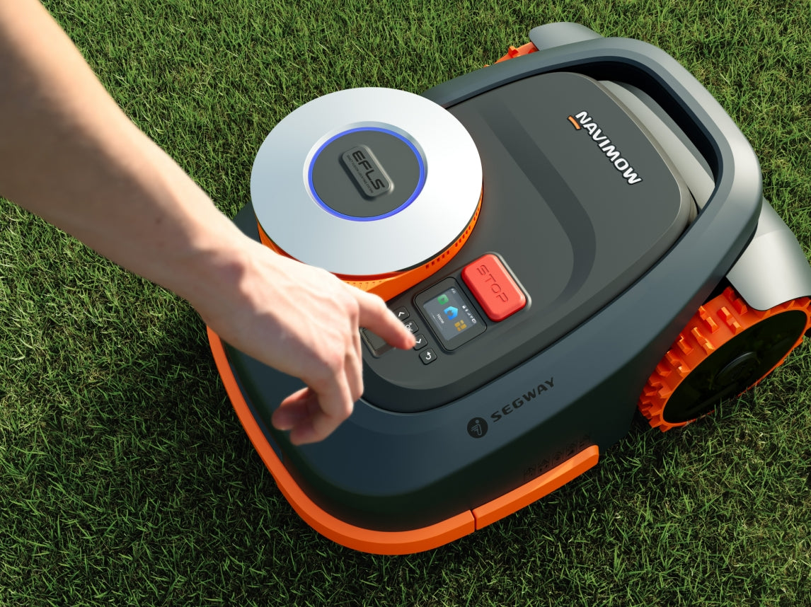 Segway Navimow H2 robot lawn mower on grass with finger on top control panel