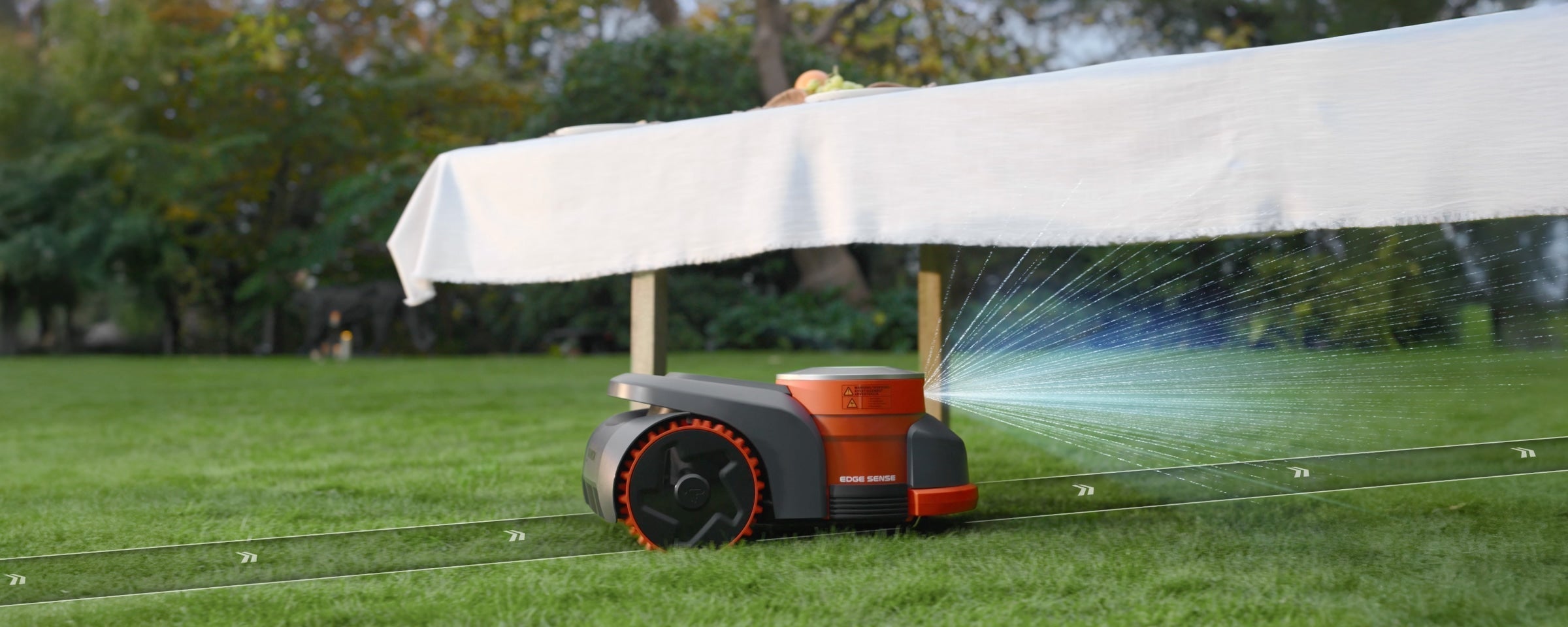 Segway Navimow H2 robot mower projects blue scan beams toward a garden table