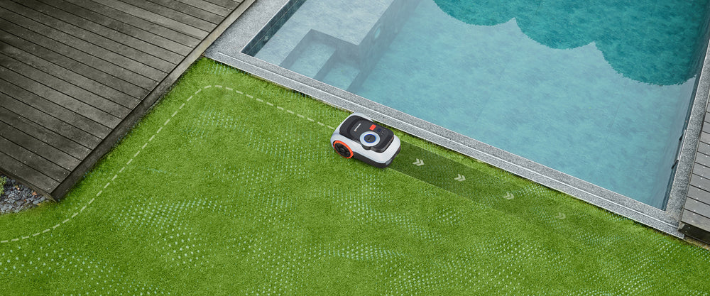 Navimow i110N robot lawn mower mows the grass near pool.